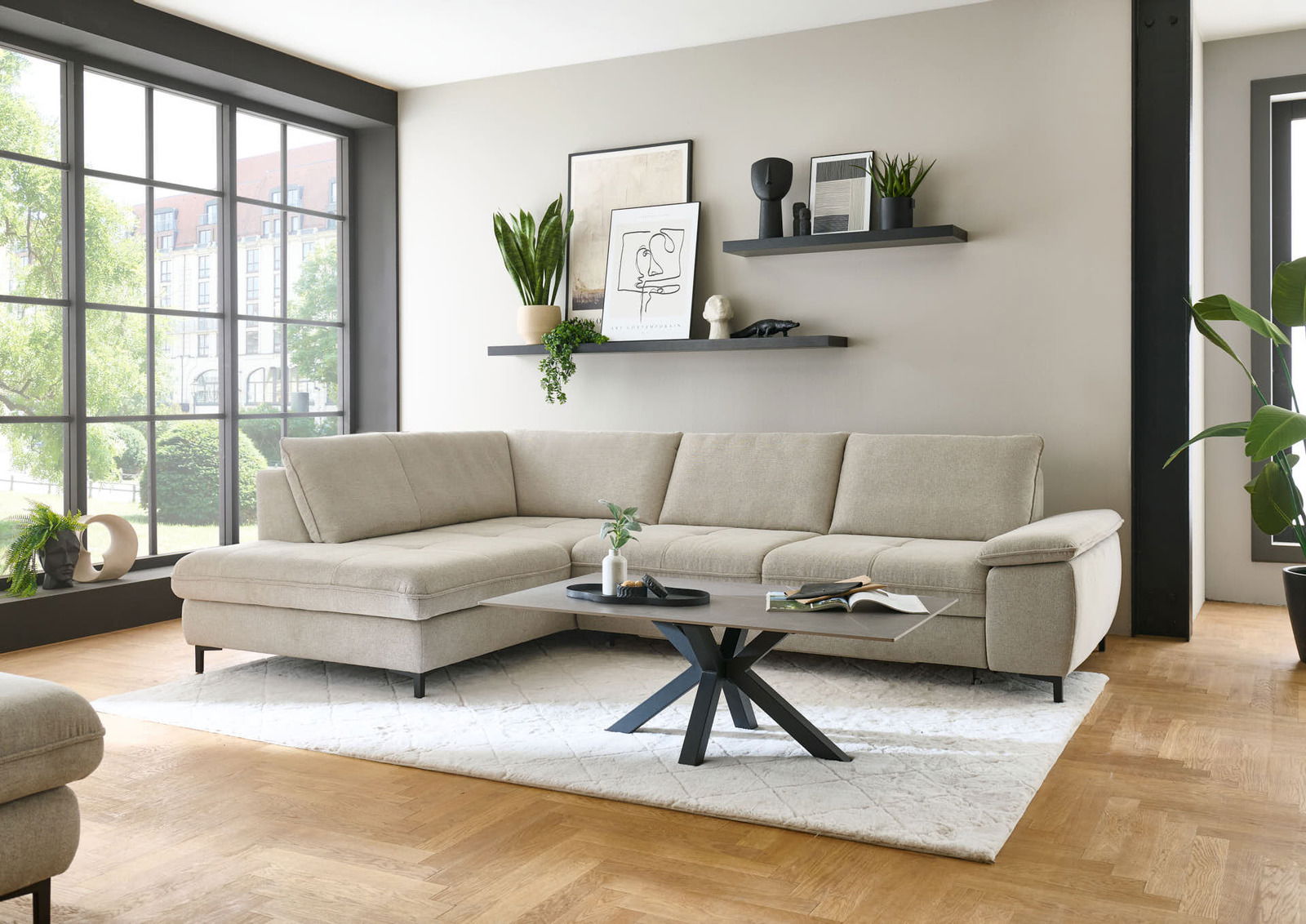 Eckgarnitur in einem modernen Wohnzimmer, seitliche Perspektive mit großen Fenstern im Hintergrund.