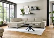 Eckgarnitur in einem modernen Wohnzimmer, seitliche Perspektive mit großen Fenstern im Hintergrund.