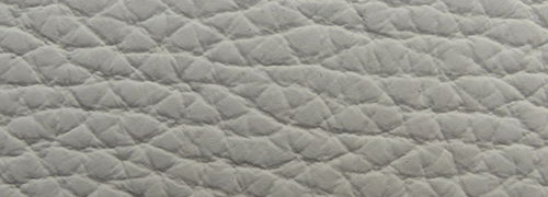 Nahaufnahme einer grauen, strukturierten Polsteroberfläche eines Sessels.