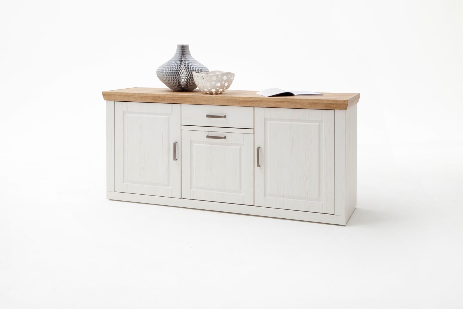 Wit dressoir/sideboard in landhuisstijl met een lichtgekleurd houten blad, drie deuren en twee lades, vrijstaand tegen een witte achtergrond, gezien van voren met een licht perspectief van linksvoor.