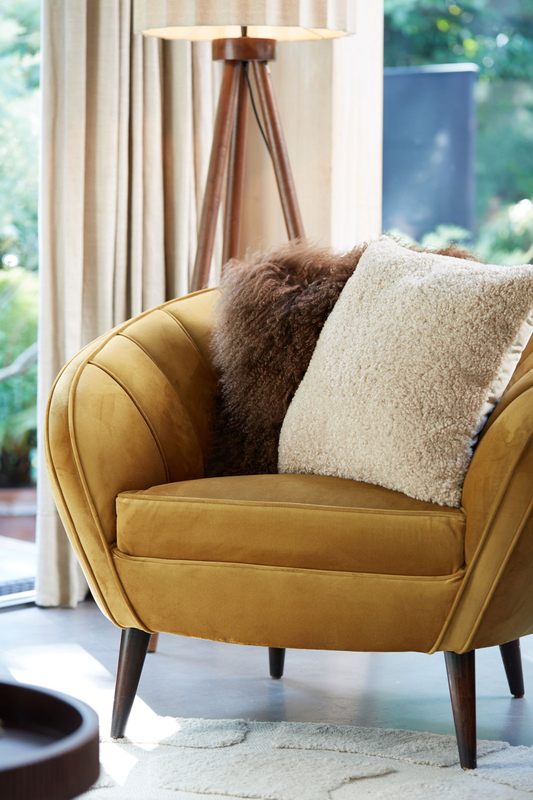 Beiges Kissen LINA 45x45 cm auf einem senfgelben Sessel, seitliche Perspektive