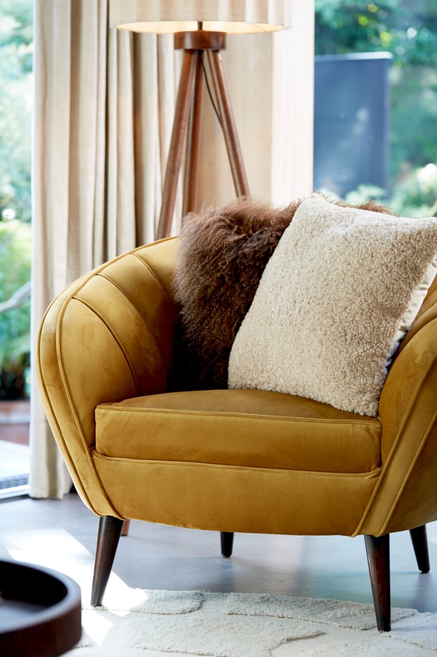 Beiges Kissen LINA 45x45 cm auf einem senfgelben Sessel, seitliche Perspektive