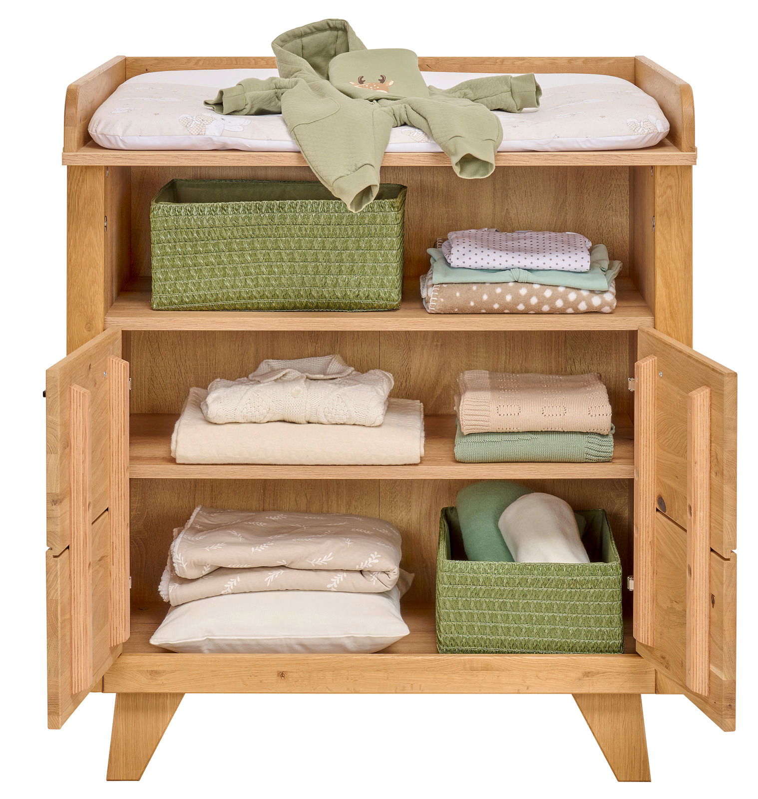 Wickelkommode klein aus Holz mit geöffneter Tür, zeigt Regale mit gefalteter Babybekleidung und grünen Aufbewahrungskörben, von vorne betrachtet.