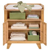 Wickelkommode klein aus Holz mit geöffneter Tür, zeigt Regale mit gefalteter Babybekleidung und grünen Aufbewahrungskörben, von vorne betrachtet.