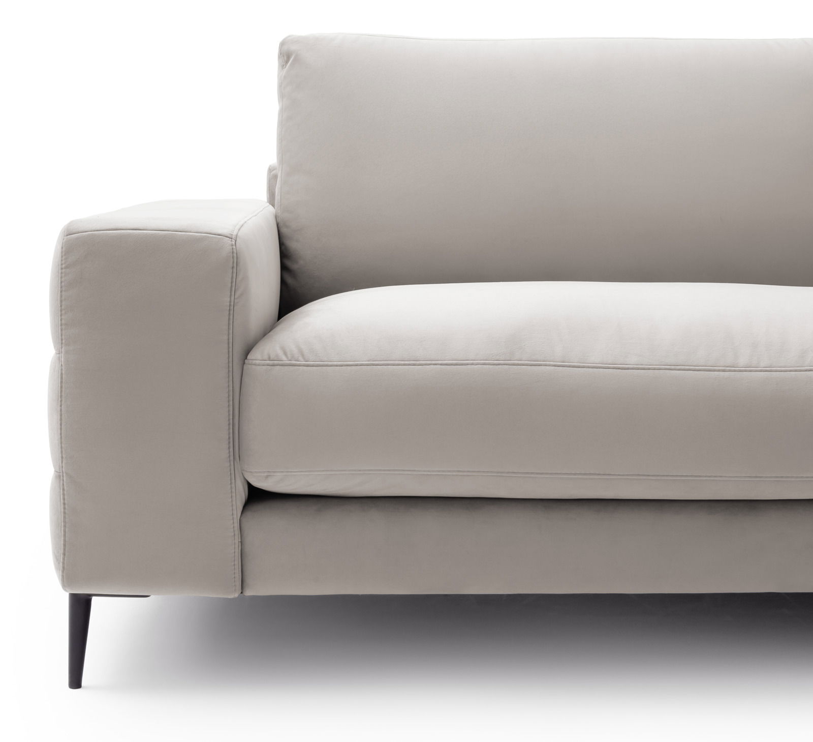 Nahaufnahme eines modernen, beigen Sofas mit Armlehne und schwarzen Beinen, seitliche Perspektive.