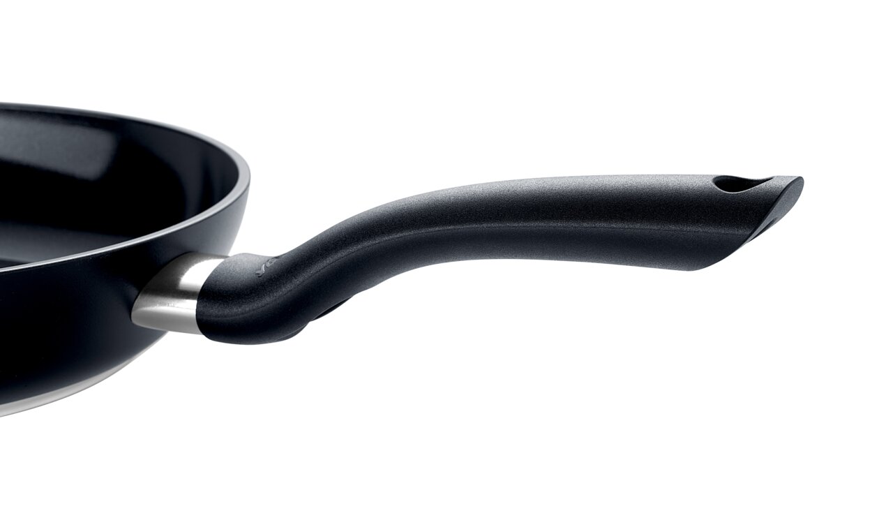 Nahaufnahme einer schwarzen Pfanne mit ergonomischem Griff, seitliche Perspektive