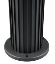 Close-up van de voet van een zwarte buitenplintlamp met geribbeld ontwerp.