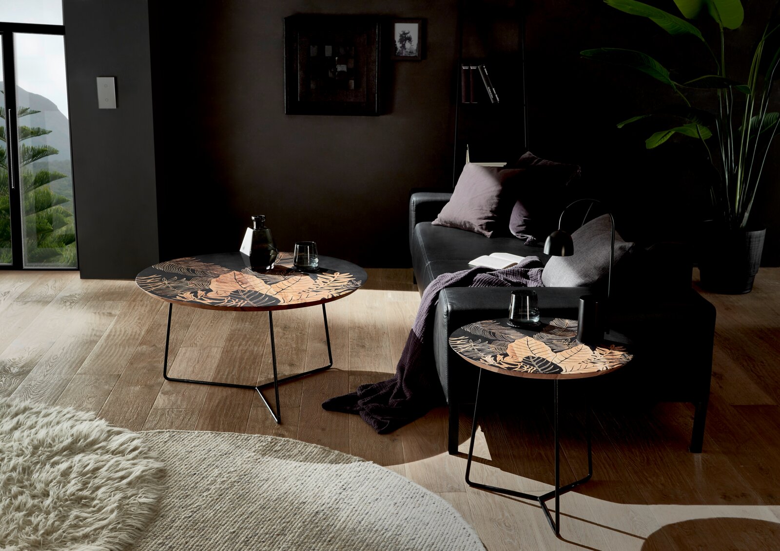Zwei Beistelltische mit floralem Muster in einem modernen Wohnzimmer, seitliche Perspektive.