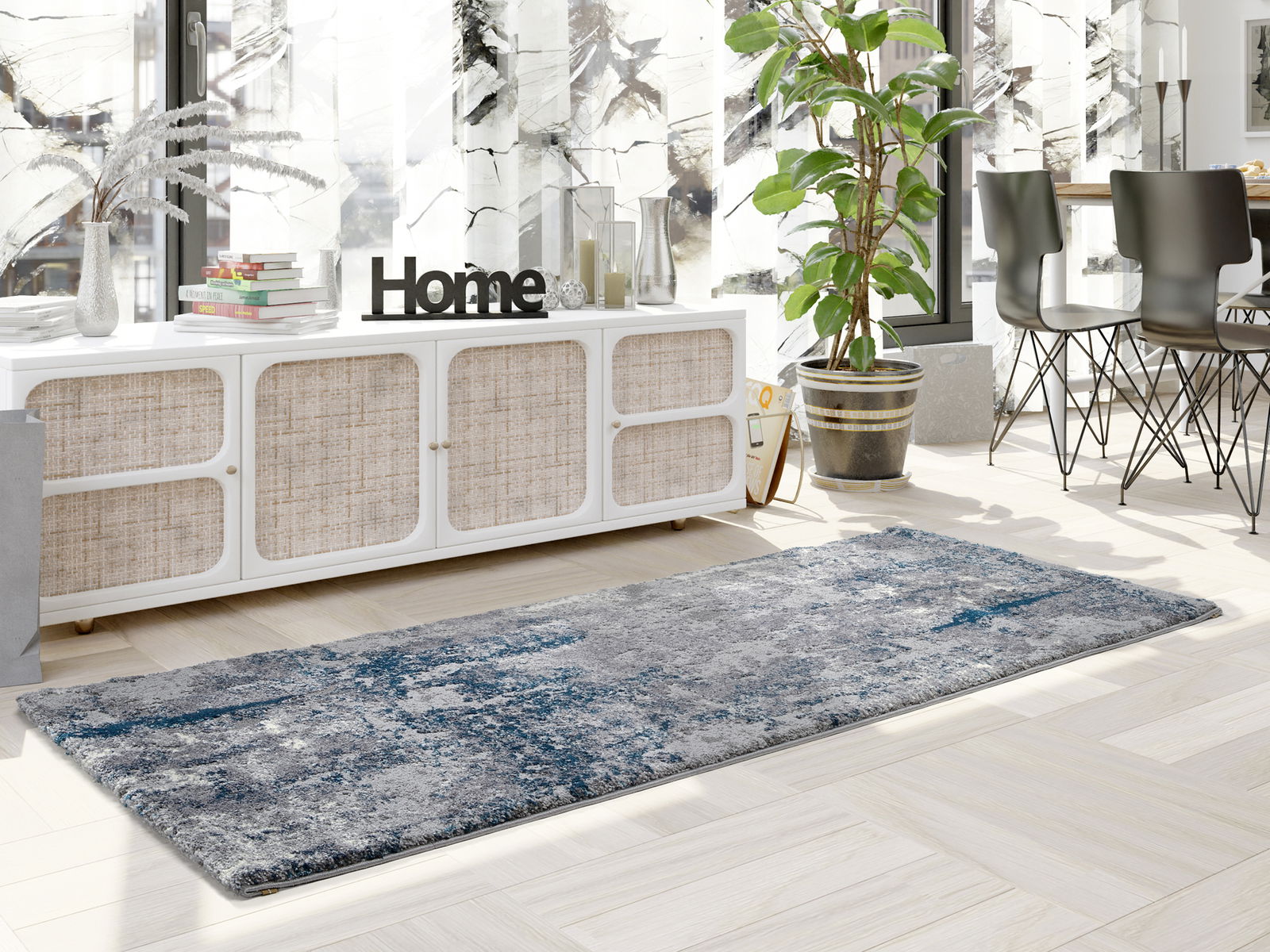Moderner Designer Teppich in Grau- und Blautönen, in einem stilvoll eingerichteten Wohnzimmer mit Blick auf eine Kommode und Pflanzen.
