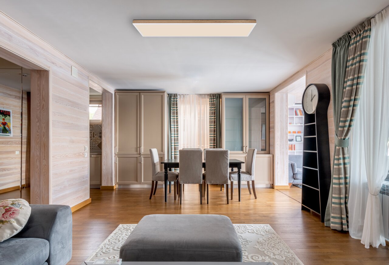 Moderne Deckenleuchte in einem stilvoll eingerichteten Wohnzimmer, aus der Perspektive des Wohnbereichs betrachtet.