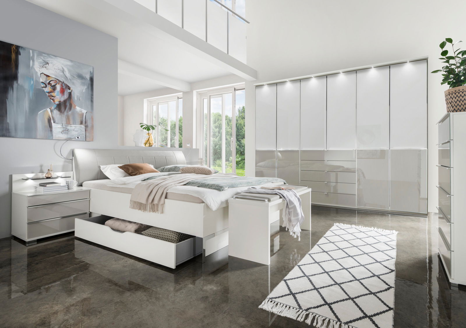 Modernes Futonbett in einem hellen Schlafzimmer mit großen Fenstern, stilvollen Möbeln und einem Kunstwerk an der Wand, aus der Perspektive von vorne links.