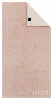Duschtuch in zartem Rosa mit umgeschlagener Ecke, zeigt das Etikett und die Marke JOOP! in der unteren rechten Ecke. Draufsicht.