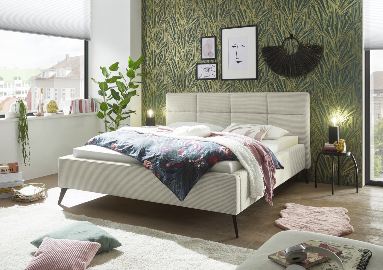 Modernes Polsterbett in einem stilvoll eingerichteten Schlafzimmer, seitliche Perspektive