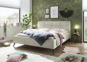 Modernes Polsterbett in einem stilvoll eingerichteten Schlafzimmer, seitliche Perspektive