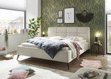 Modernes Polsterbett in einem stilvoll eingerichteten Schlafzimmer, seitliche Perspektive