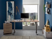 Moderner E-Schreibtisch in einem stilvollen Büro mit Blick auf die Natur durch ein großes Fenster. Der Schreibtisch ist aus Holz mit Metallbeinen und bietet Platz für einen Computer und Schreibtischzubehör. Perspektive: Frontalansicht.