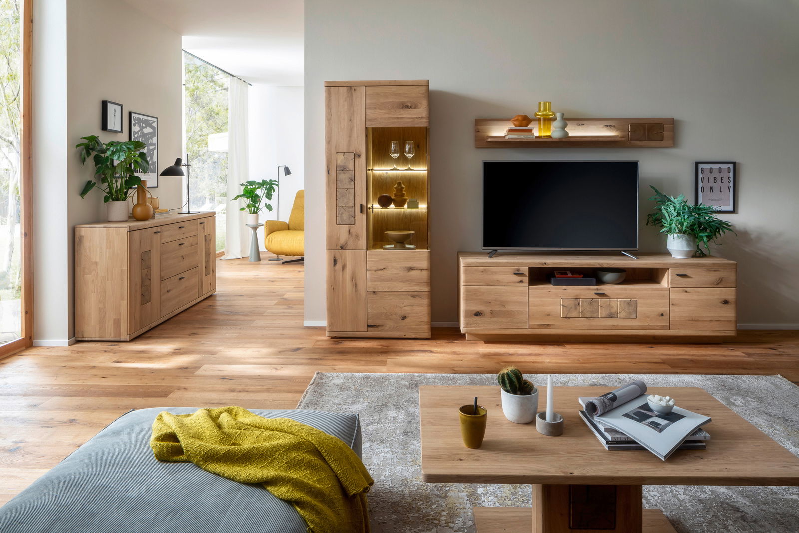 Linea Natura Vitrine PHÖNIX Wohnzimmer mit moderner Holzmöbelkombination, bestehend aus Sideboard, Vitrine und TV-Board, aus der Perspektive des Sofas betrachtet.