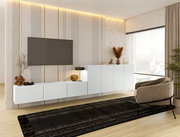 Modernes TV-Hängelowboard in Weiß, montiert an einer stilvoll gestalteten Wand mit dekorativen Streifen, seitliche Perspektive.