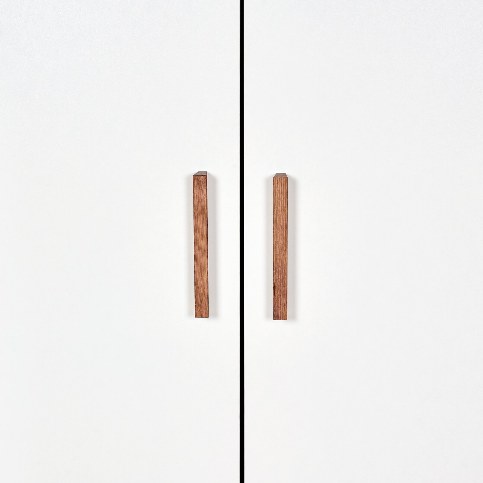 Vorderansicht eines weißen Kleiderschranks mit zwei Holztürgriffen.