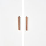 Vorderansicht eines weißen Kleiderschranks mit zwei Holztürgriffen.