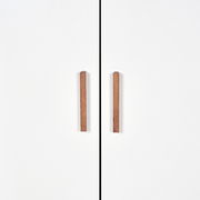 Vorderansicht eines weißen Kleiderschranks mit zwei Holztürgriffen.