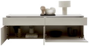 Frontale Ansicht eines modernen TV-Lowboards in hellem Beige mit offenen Fächern, dekoriert mit Büchern, Vasen und einer Tischlampe.