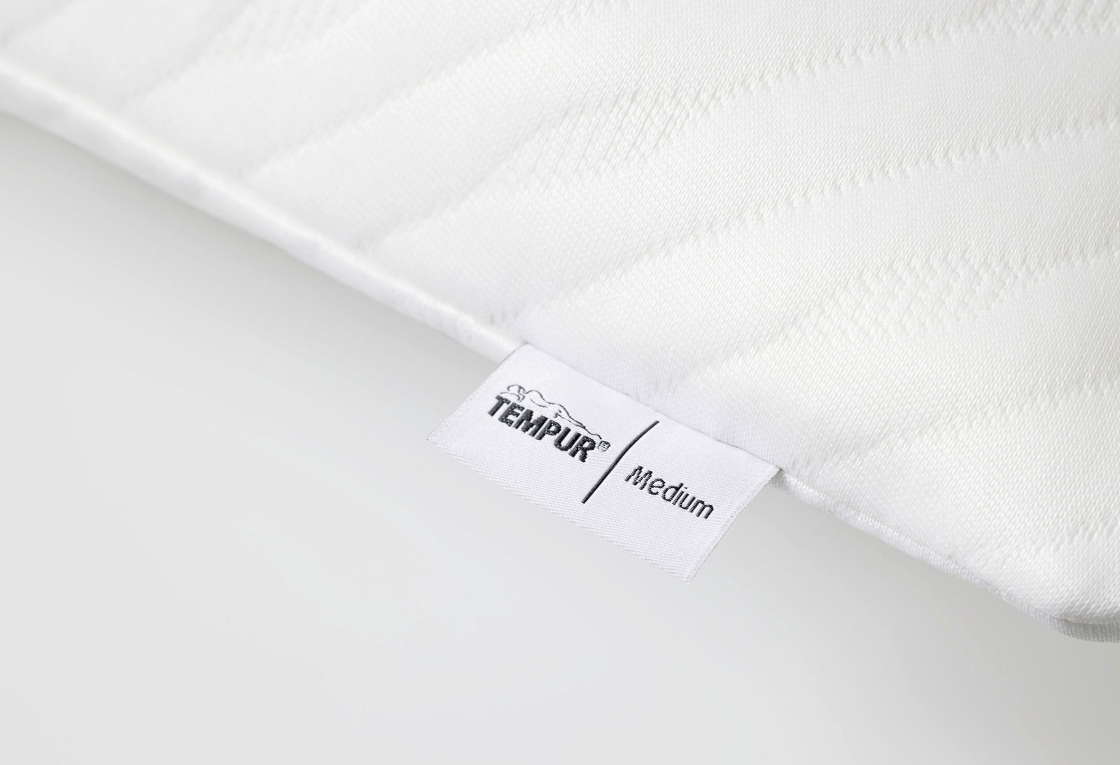 Nahaufnahme eines weißen Schlafkissens mit TEMPUR-Label, Perspektive von der Seite