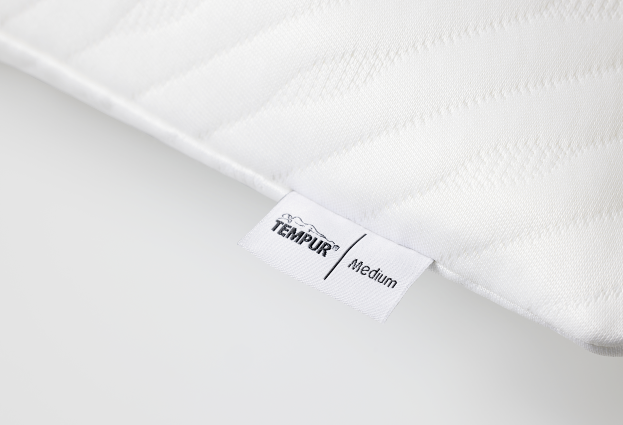 Nahaufnahme eines weißen Schlafkissens mit TEMPUR-Label, Perspektive von der Seite