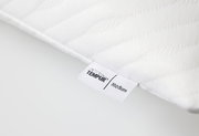 Nahaufnahme eines weißen Schlafkissens mit TEMPUR-Label, Perspektive von der Seite