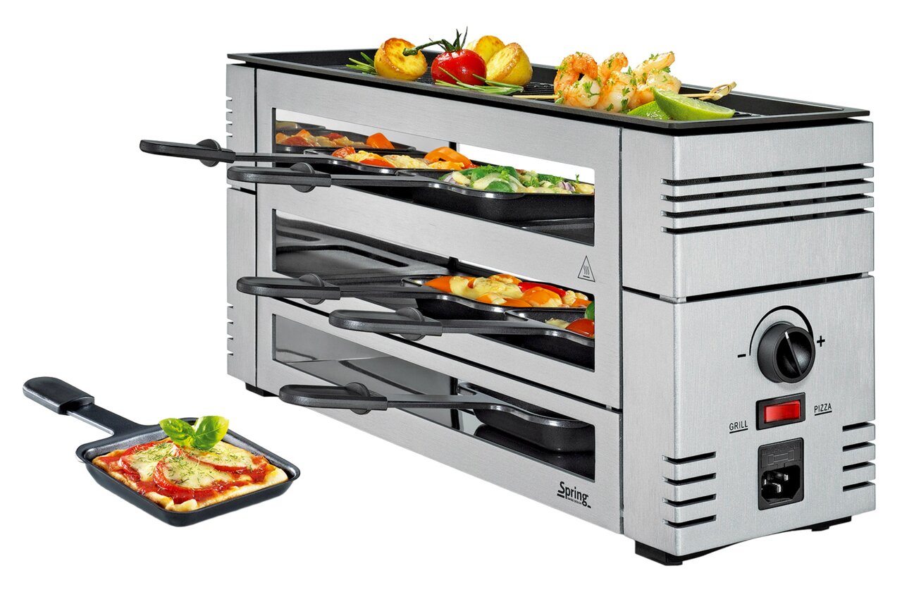 Zilveren pizza-raclette-apparaat met meerdere niveaus, gevuld met pannetjes vol ingrediënten, en een grillplaat bovenop, gezien vanuit een zijaanzicht.