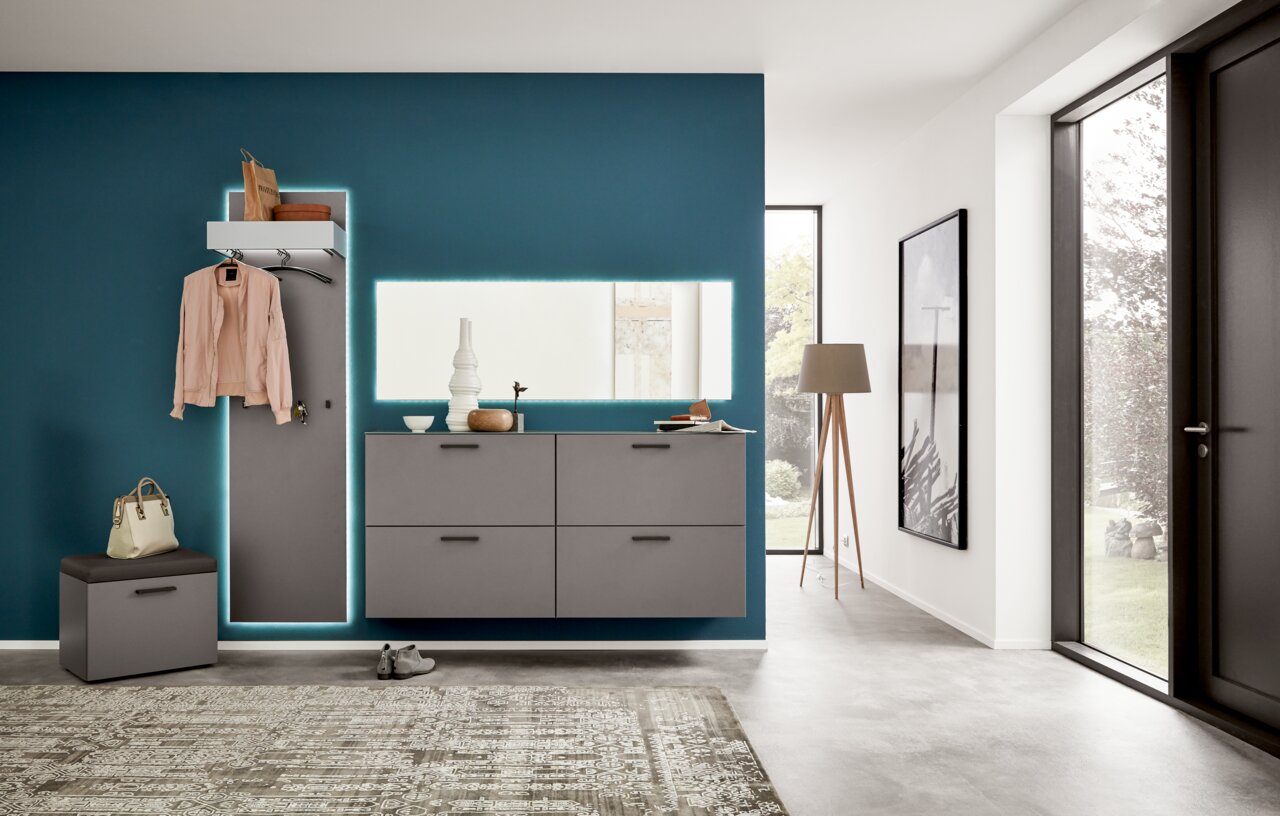 Moderne Garderoben-Set mit grauen Schränken und beleuchtetem Spiegel, seitliche Perspektive