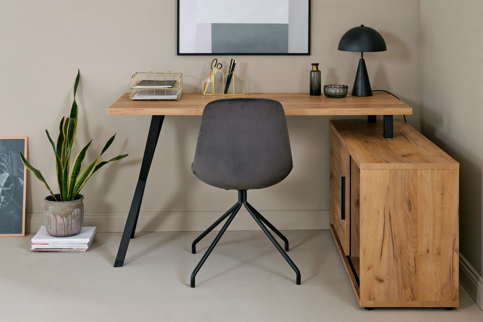 Eck-Schreibtisch-Kombination aus Holz mit schwarzem Metallgestell, grauer Stuhl mit schwarzem Gestell, dekoriert mit Lampe, Pflanzen und Büroaccessoires, Perspektive von vorne.