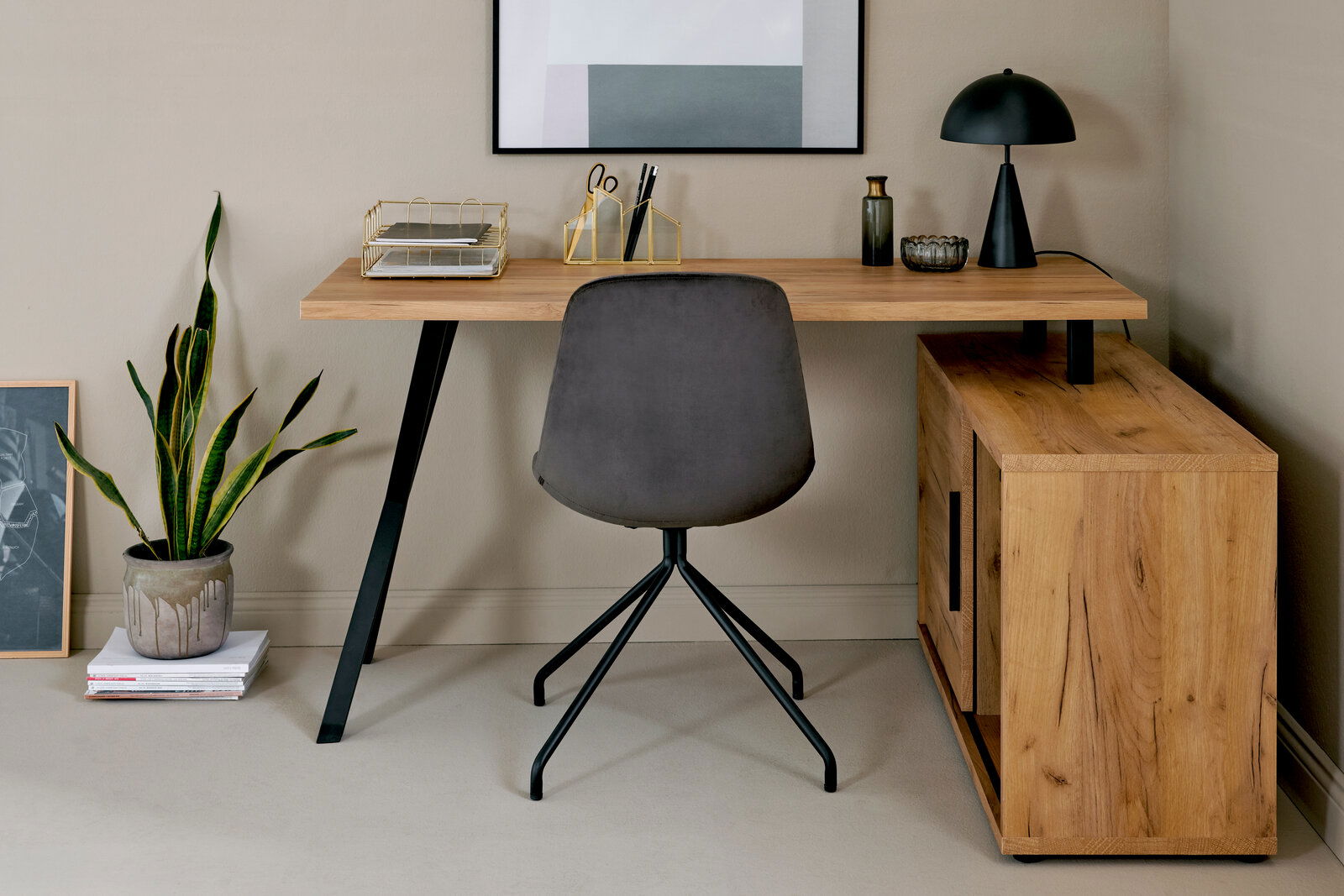 Eck-Schreibtisch-Kombination aus Holz mit schwarzem Metallgestell, grauer Stuhl mit schwarzem Gestell, dekoriert mit Lampe, Pflanzen und Büroaccessoires, Perspektive von vorne.