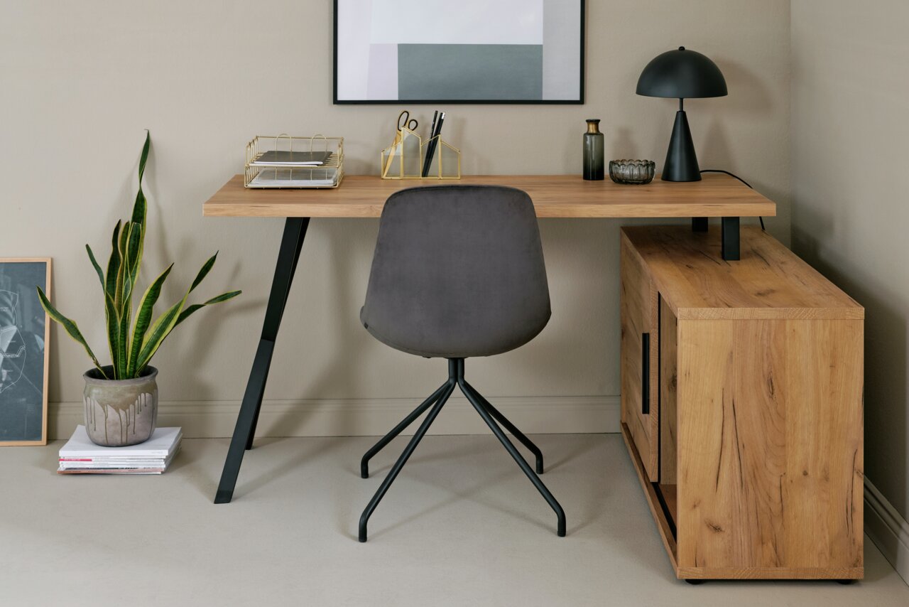 Hoekbureau van hout met een zwart metalen onderstel, grijze stoel met zwart onderstel, versierd met een lamp, planten en kantooraccessoires, vooraanzicht.