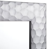 Nahaufnahme eines Spiegels mit facettiertem, geometrischem Rahmen in Silberoptik, Perspektive von der Ecke des Rahmens.