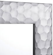 Nahaufnahme eines Spiegels mit facettiertem, geometrischem Rahmen in Silberoptik, Perspektive von der Ecke des Rahmens.