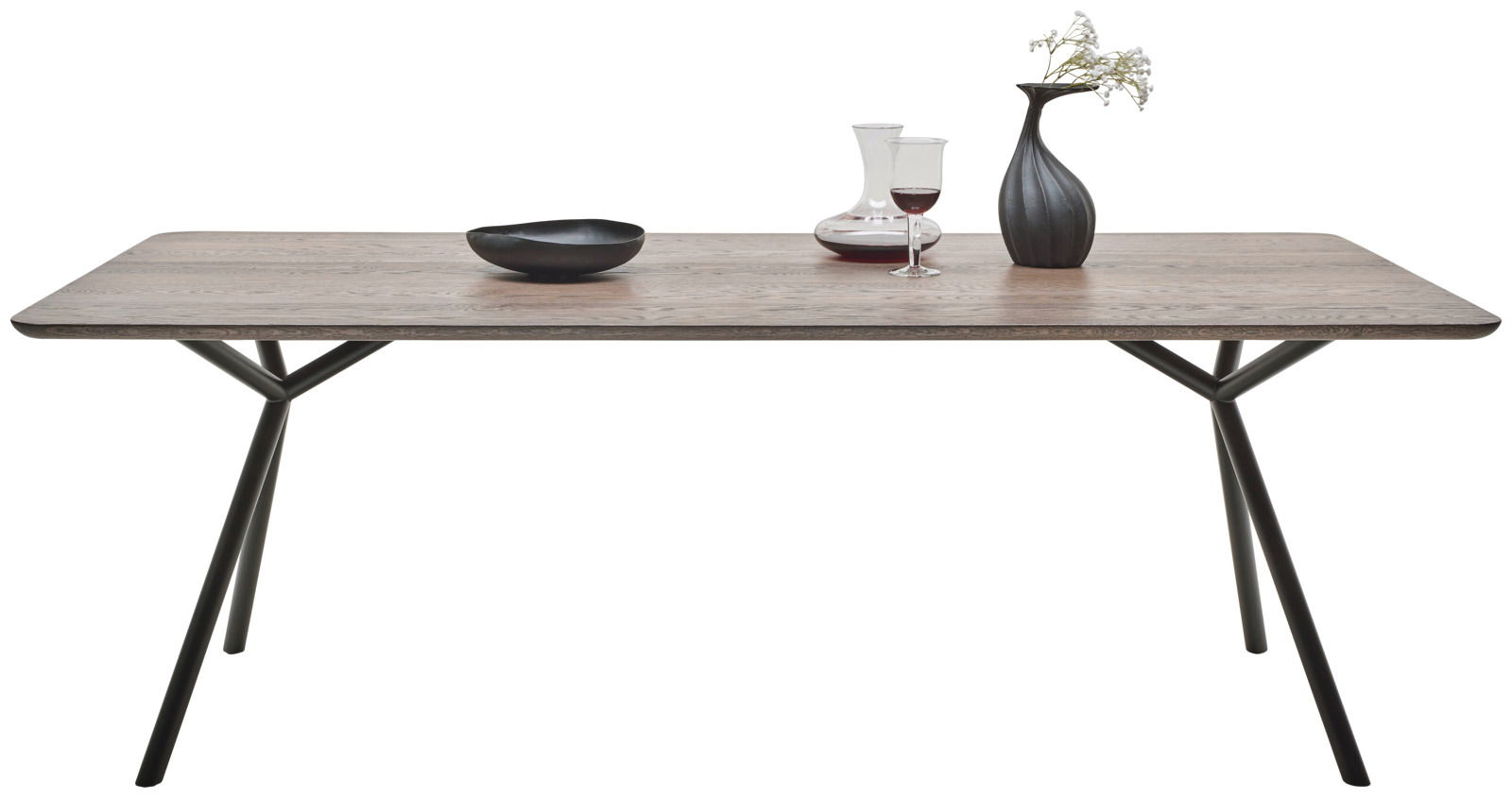 Moderner Esstisch aus Holz mit Metallbeinen, dekoriert mit einer Vase, einem Weinglas und einer Schale, seitliche Perspektive