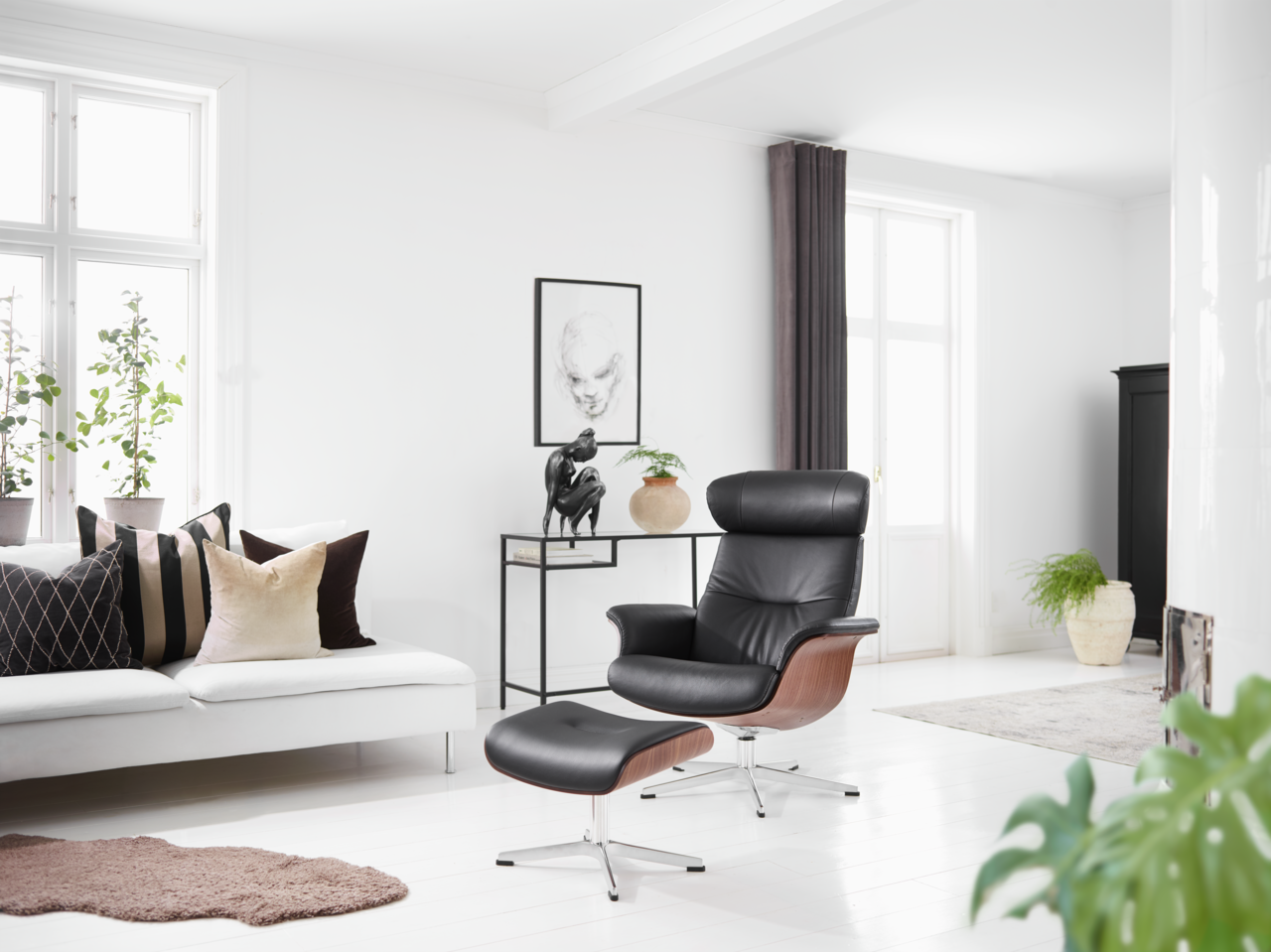 Zurbrüggen Hocker fest TIME OUT Moderner schwarzer Ledersessel mit Hocker in einem hellen Wohnzimmer, seitliche Perspektive