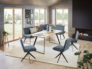 Moderne Eckbank 203x163 cm in einem hellen Wohnzimmer mit großen Fenstern, umgeben von stilvollen Stühlen und einem Holztisch, aus der Perspektive des Raumes betrachtet.