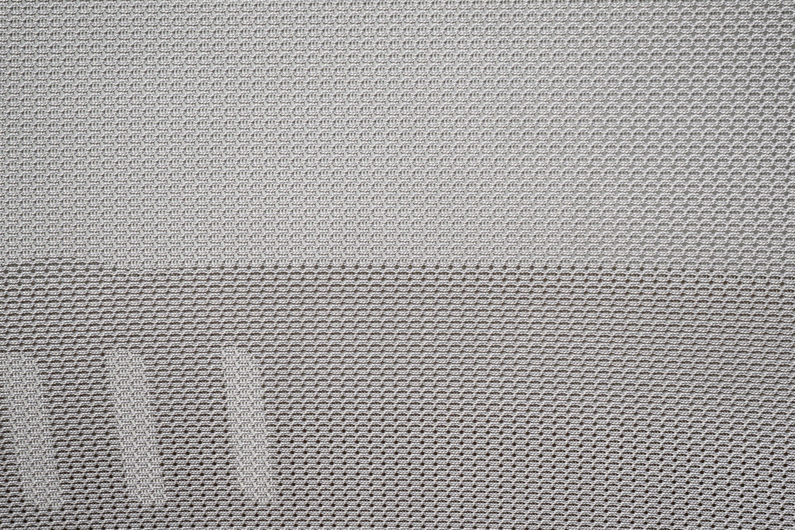 Nahaufnahme des Netzstoffs eines Drehstuhls aus seitlicher Perspektive