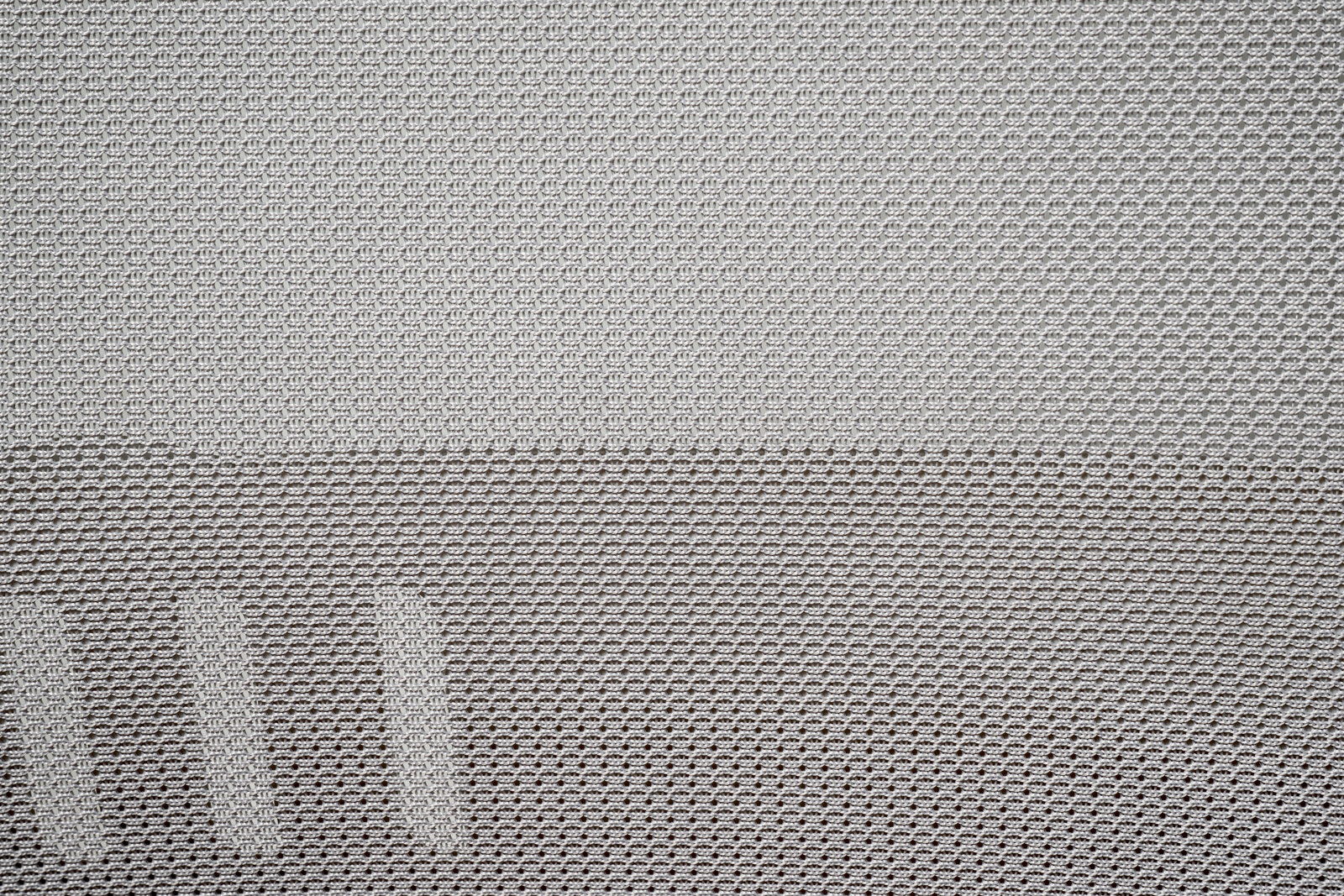 Nahaufnahme des Netzstoffs eines Drehstuhls aus seitlicher Perspektive