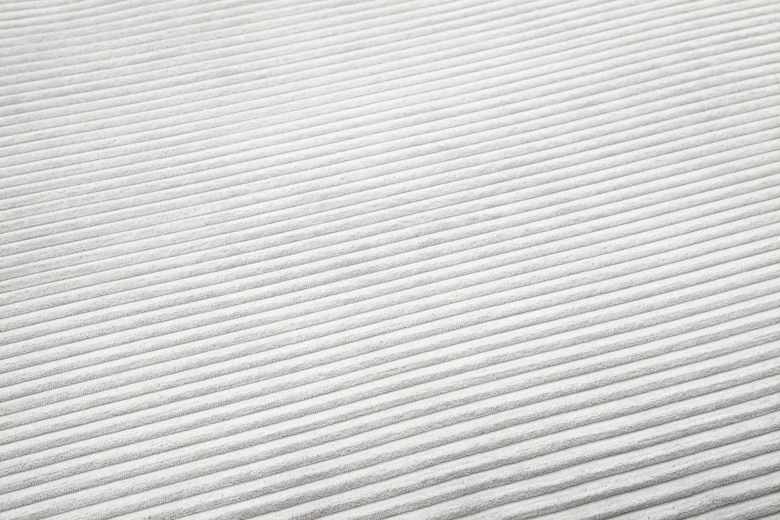 Nahaufnahme eines weißen, gerippten Stoffes in diagonaler Perspektive