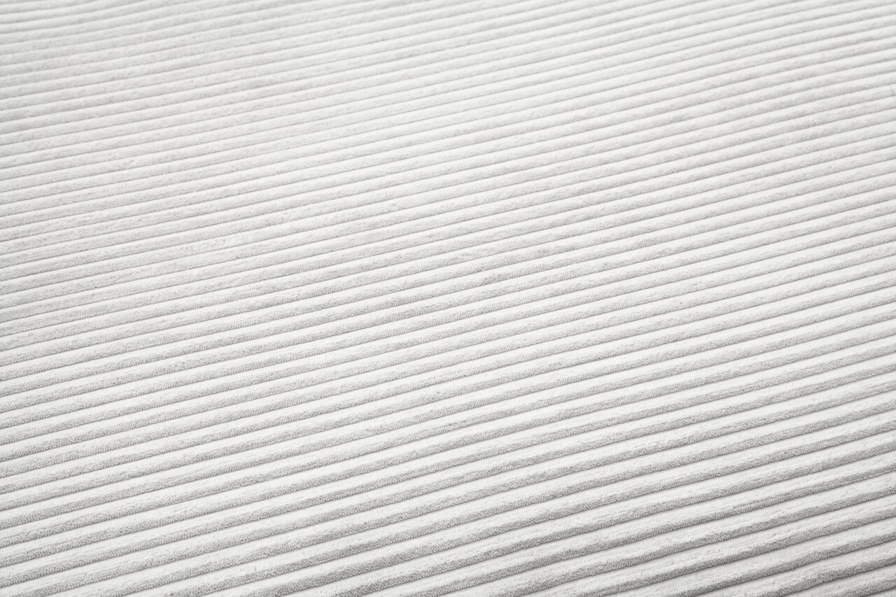 Nahaufnahme eines weißen, gerippten Stoffes in diagonaler Perspektive