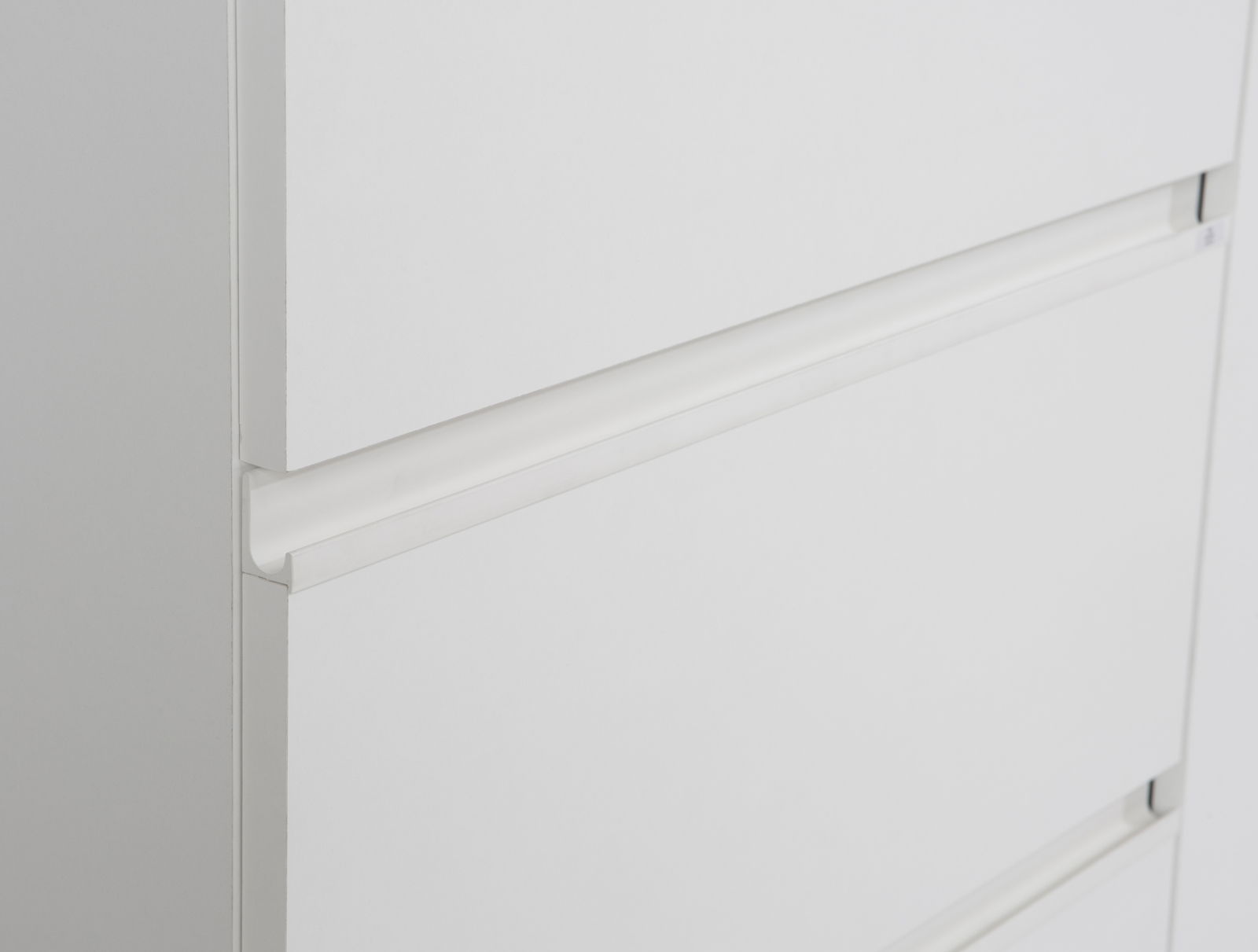 Nahaufnahme eines weißen Schwebetürenschranks mit klaren Linien und minimalistischen Griffen, seitliche Perspektive.
