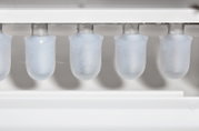 Close-up in vooraanzicht van kogelvormige ijsblokjes die in een automatische ijsblokjesmachine worden gevormd