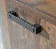 Nahaufnahme einer Kommode mit rustikaler Holzoptik und schwarzem Metallgriff, seitliche Perspektive