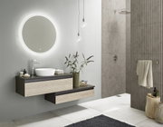 Moderne badkamercombinatie met ronde verlichte spiegel, wastafel en onderkast in houtlook, zijaanzicht