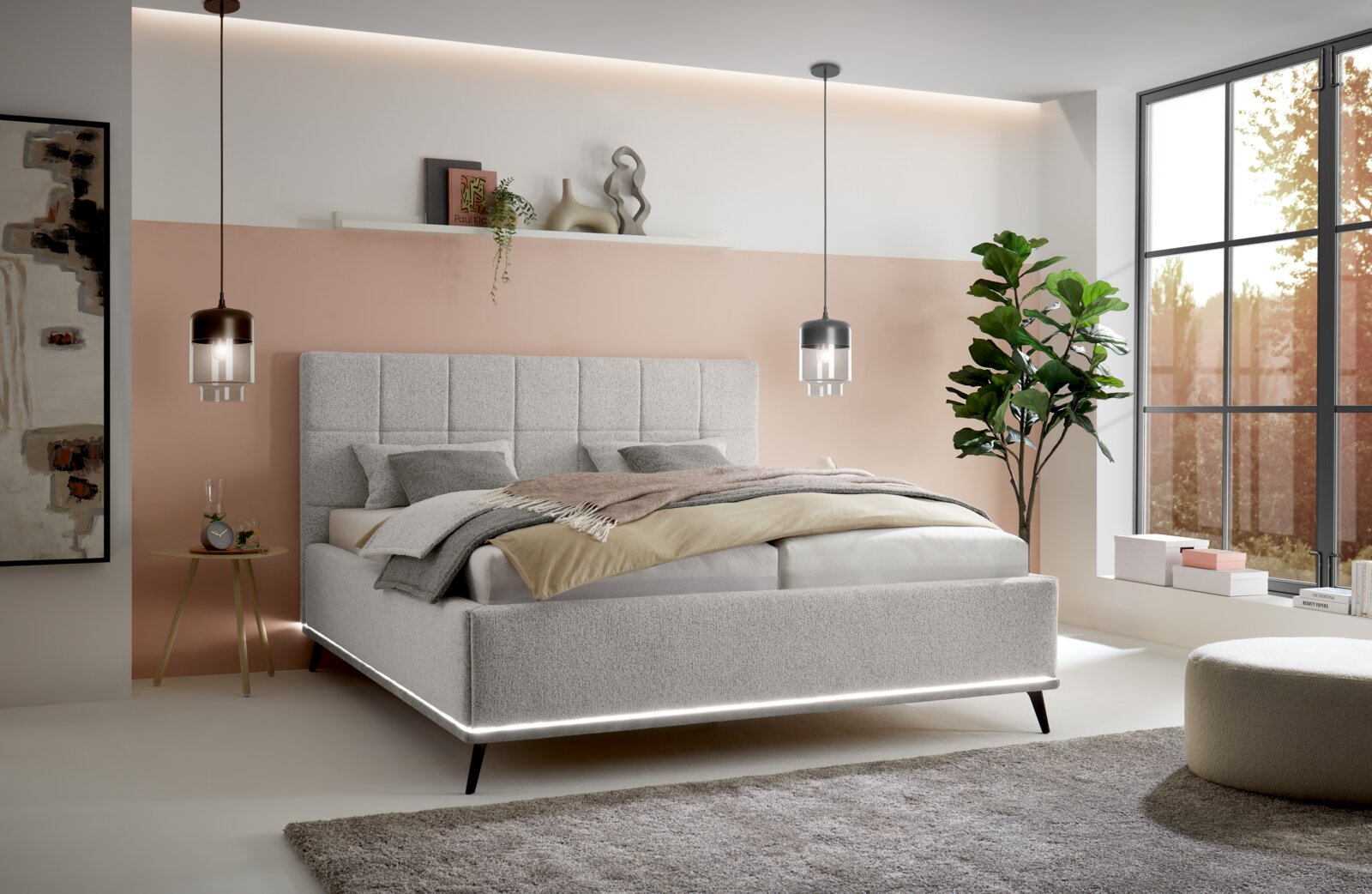 Modernes Polsterbett in Hellgrau mit gepolstertem, quadratisch gestepptem Kopfteil und umlaufender LED-Lichtleiste am Bettrahmen, im Schlafzimmer-Setting; Perspektive: frontale 3/4-Ansicht von leicht links.