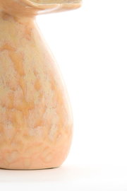 Nahaufnahme einer Vase mit pastellfarbenem, marmoriertem Muster, seitliche Perspektive