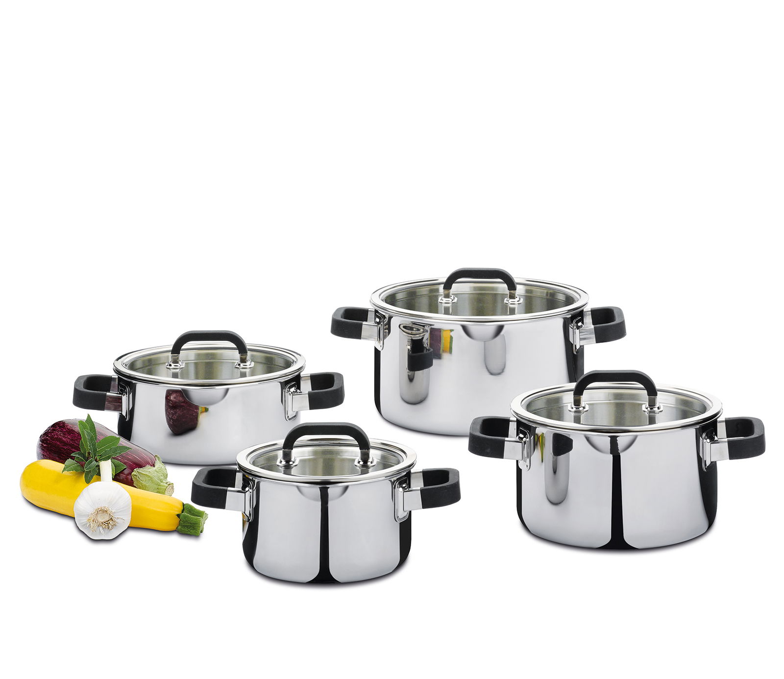 Vierteiliger Topfset Fusion2+ aus Edelstahl mit Glasdeckeln, seitliche Perspektive, umgeben von frischem Gemüse.